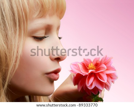 Profile of beautiful girl with flower on pink background