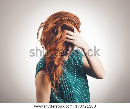 Sad Young Woman Looks Down And Covers Eyes