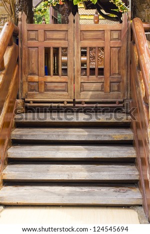 The ancient wooden carving stair with folding door or saloon door.