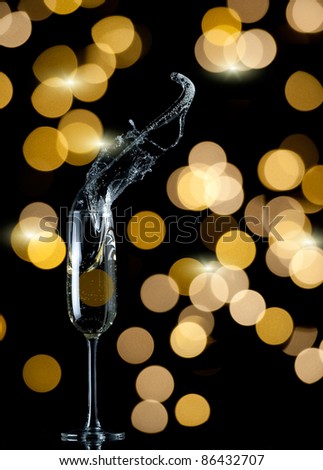 champagne flute splash with blurred lights background