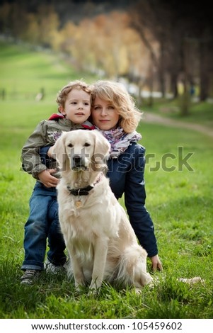 Mother and son in the park along with a golden retriever.