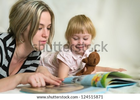 Mother and daughter looking at children\'s book