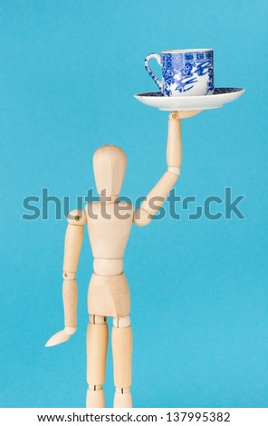 Conceptual image of work at cafe. Wood figurine waitress serve cup of coffee.