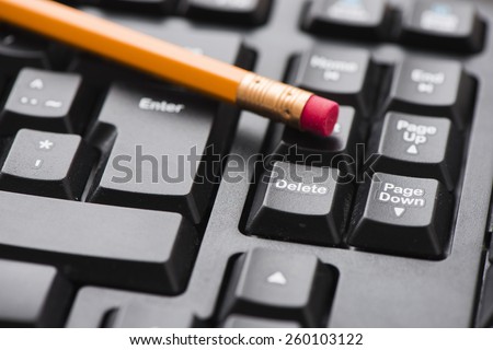 Closeup of keyboard and pencil. Delete key and eraser on pencil in focus. Conceptual image of deleting sensitive data, hardware crash and losing digital information.
