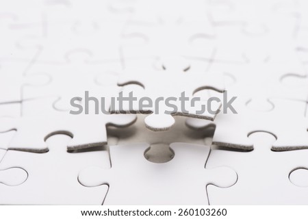 Puzzle pieces, one piece floating in air. Conceptual image of connection, solution and business strategy.