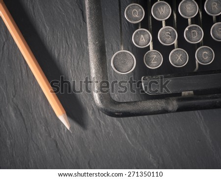 Retro vintage typewriter and pencil. Conceptual image of old fashioned office work, communication or writing.