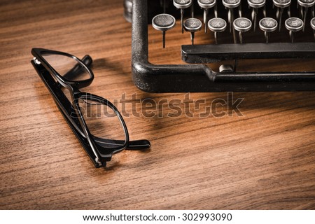 Retro vintage typewriter and glasses. Conceptual image of old fashioned office work, communication or writing.