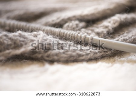 Close up of gray wool and knitting equipment . Soft fabric and needle with shallow depth of field.