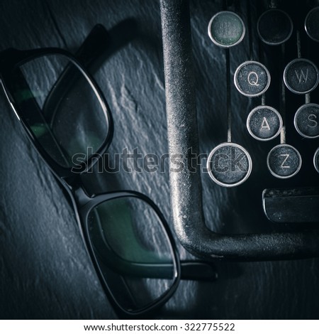 Retro vintage typewriter and glasses. Conceptual image of old fashioned office work, communication or writing.