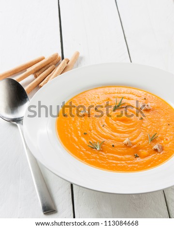 homemade pumpkin cream with herbs, nuts and bread sticks