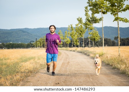 Guy running with a dog in the nature