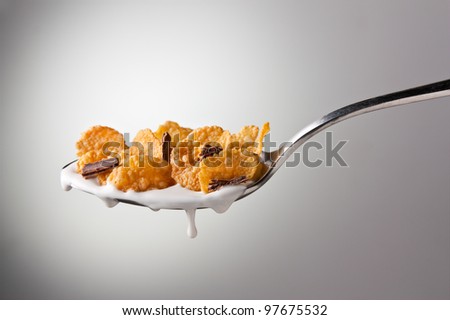 Tasty cereal on a spoon on white background