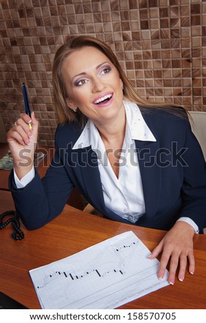 Business woman sitting at a table with a pen in hand to find solutions