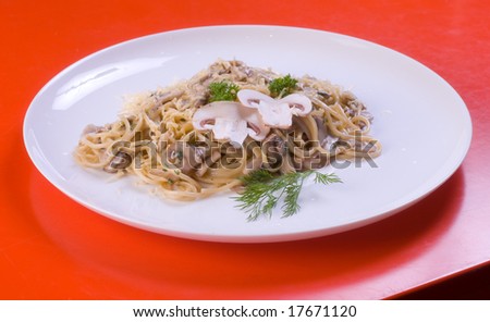 Freshly cooked plate of spaghetti with champignons sprinkled with fresh green herbs