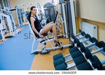 young beautiful girl swings his feet in the gym