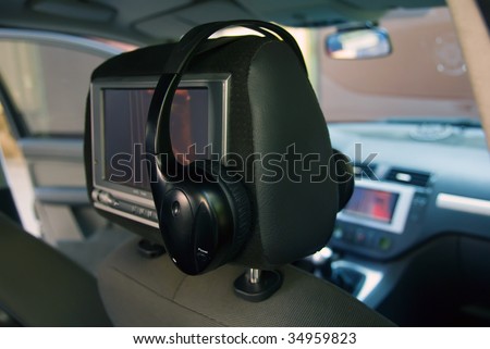 in the back seat of a car mounted the screen to view video and attached headphones