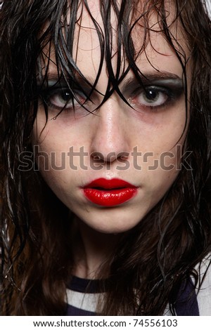 Close up portrait of beauty young girl with wet hairs and face with red glossy lipstick, bright makeup in studio