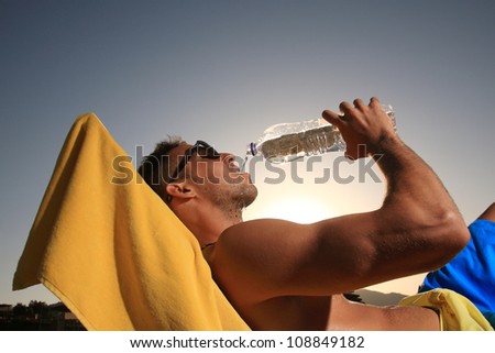 handsome male drinking water at the beach
