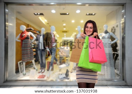 happy young girl with shopping bags outside a store