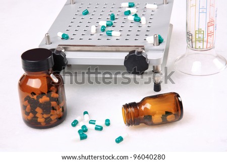 medicine pills pouring out of orange bottle on a white marble. selective focus