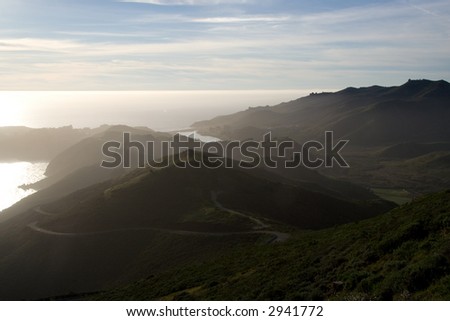 Ocean view with hills in sunset mist