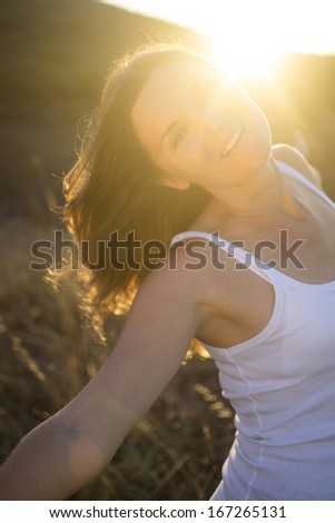 Beautiful young woman stretching her arms joyfully praising the beauty of Life.