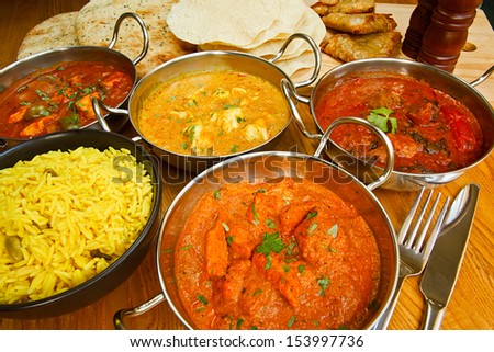 Selection of indian food with pilau rice, naan bread, poppadoms and samosas a popular choice for eating out in european countries