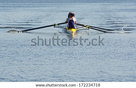 Rowing team working in unison to compete in a regatta by racing specially built row boats