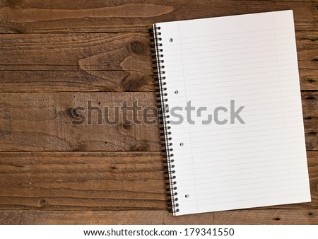 Lined A4 ring bound pad on a double page spread rustic wooden background in portrait orientation with copy space to the left for insertion of your message, photographs or design elements.