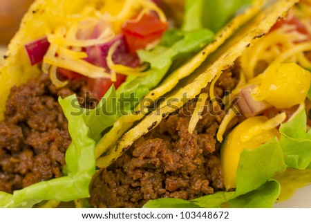 Beef Tacos - Mexican minced beef hard-shell tacos with salsa, cheese and lettuce. Close up.
