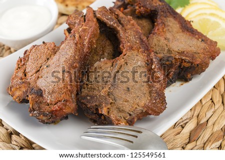 Tikka Lamb Chops - South Asian grilled lamb chops served with lemon wedges and raita.