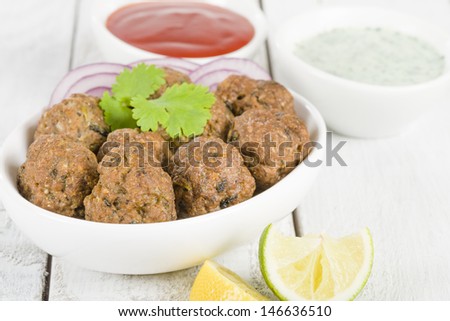 Kofta - South Asian spicy meatballs served with chili sauce and mint and yoghurt dip.