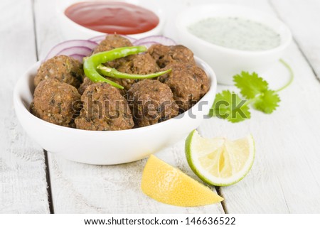 Kofta - South Asian spicy meatballs served with chili sauce and mint and yoghurt dip.