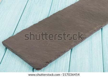 Empty Slate - Black serving platter on a blue wooden table.