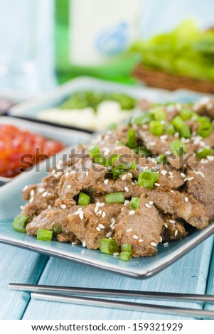 Bulgogi - Korean grilled marinated beef served with green chillies, garlic, ssamjang, kimchi and lettuce leaves.