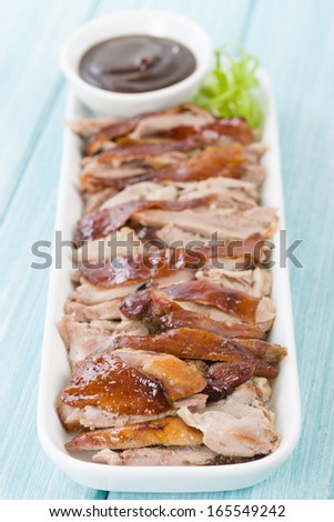 Peking Duck - Chinese roast crispy duck served with hoisin sauce on a blue background.