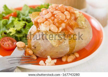 Jacket Potato - Baked potato topped with cheese and baked beans served with salad.
