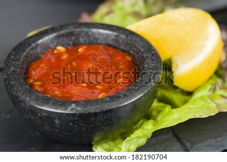 Chilli Sauce - Asian style chili sauce in a granite bowl on a black background.