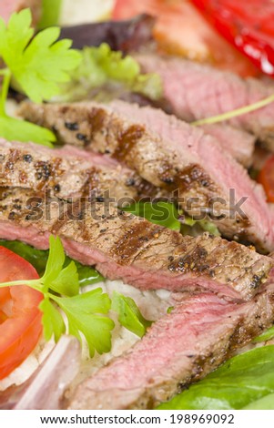 Grilled Beef Wraps - Griddled sirloin steak, sliced and wrapped in a flatbread served with blue cheese sauce and salad. Close up.