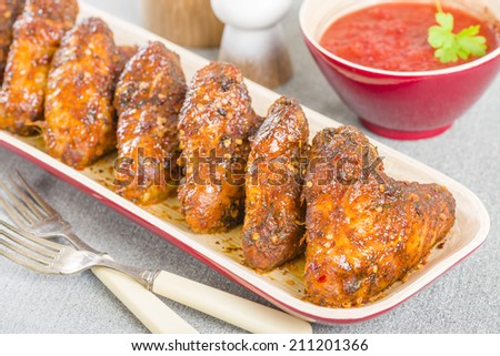 Spicy Hot Chicken Wings - Platter of chicken wings coated in hot sauce.