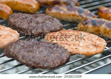 BBQ - Exotic meat burgers and sausages on a lit barbecue (kangaroo, crocodile and wild boar).