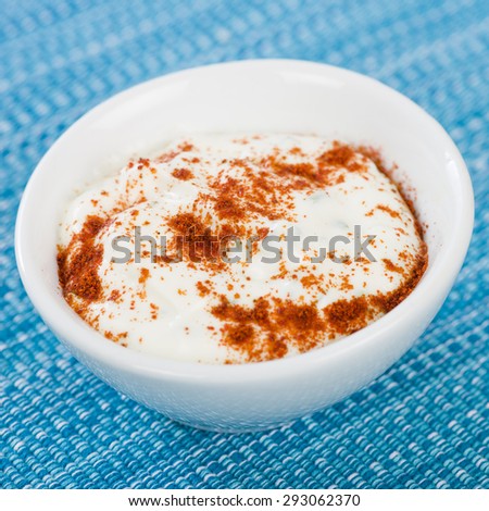Paprika & Chive Dip - Sour cream and chive dip dusted with smoked paprika  on a blue background.