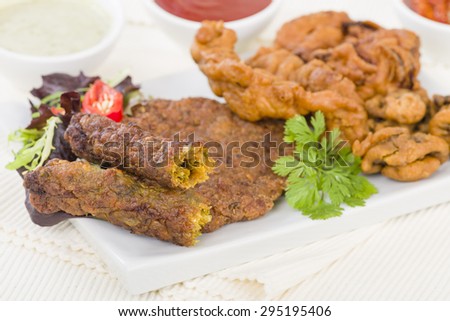 South Asian Starters - Selection of seekh and shami kebabs, mushroom and chicken pakoras and onion bhajjis. Served with salad, mint raita, lime pickled and chilli sauce.