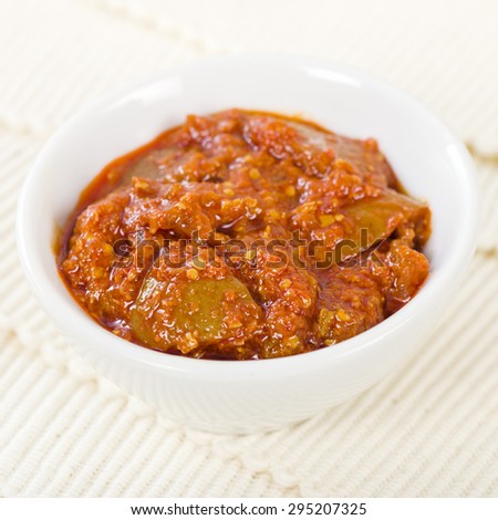 Lime Chutney - Indian lime pickle in a white bowl and cream background.