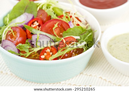 Mixed Leaf & Vegetable Summer Salad - Salad with tomatoes, rocket, lettuce, red onions and peppers and dressing on the side.
