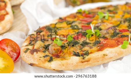 Veggie Pizza - Vegetarian mini pizza on a wooden background.