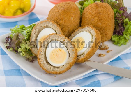 Scotch Egg - Hard-boiled egg wrapped in sausage meat, coated in breadcrumbs and deep-fried. Served with salad and piccalilli.