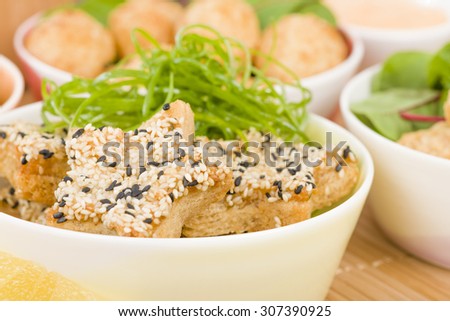 Sesame Prawn Toast - Star shaped shrimp toast and other party food on background.
