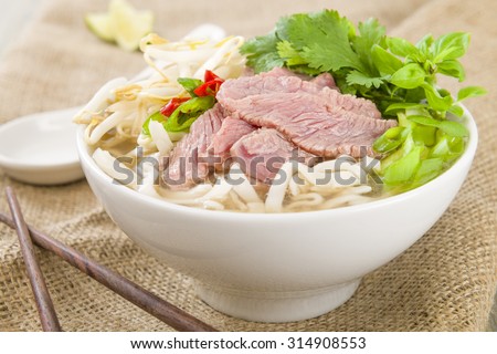Pho Bo - Vietnamese fresh rice noodle soup with beef, herbs and chili. Vietnam\'s national dish.