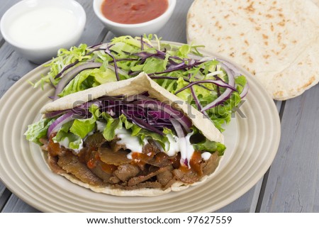 Donner Kebab - Turkish donner meat in a pitta bread served with chili sauce, garlic mayonnaise and crunchy salad.